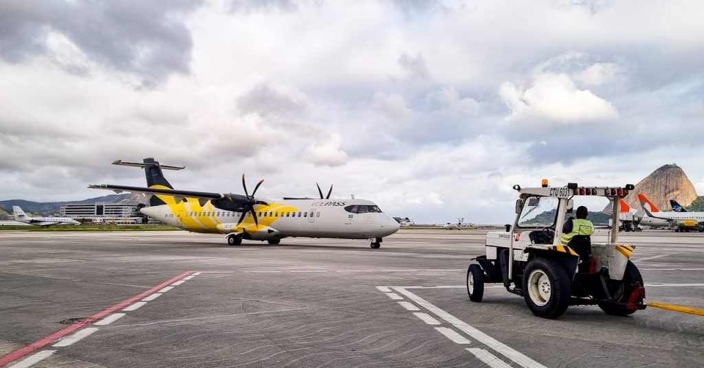 A propeller airplane on the runway with ground crew assistance in Rio de Janeiro airport, Brazil.